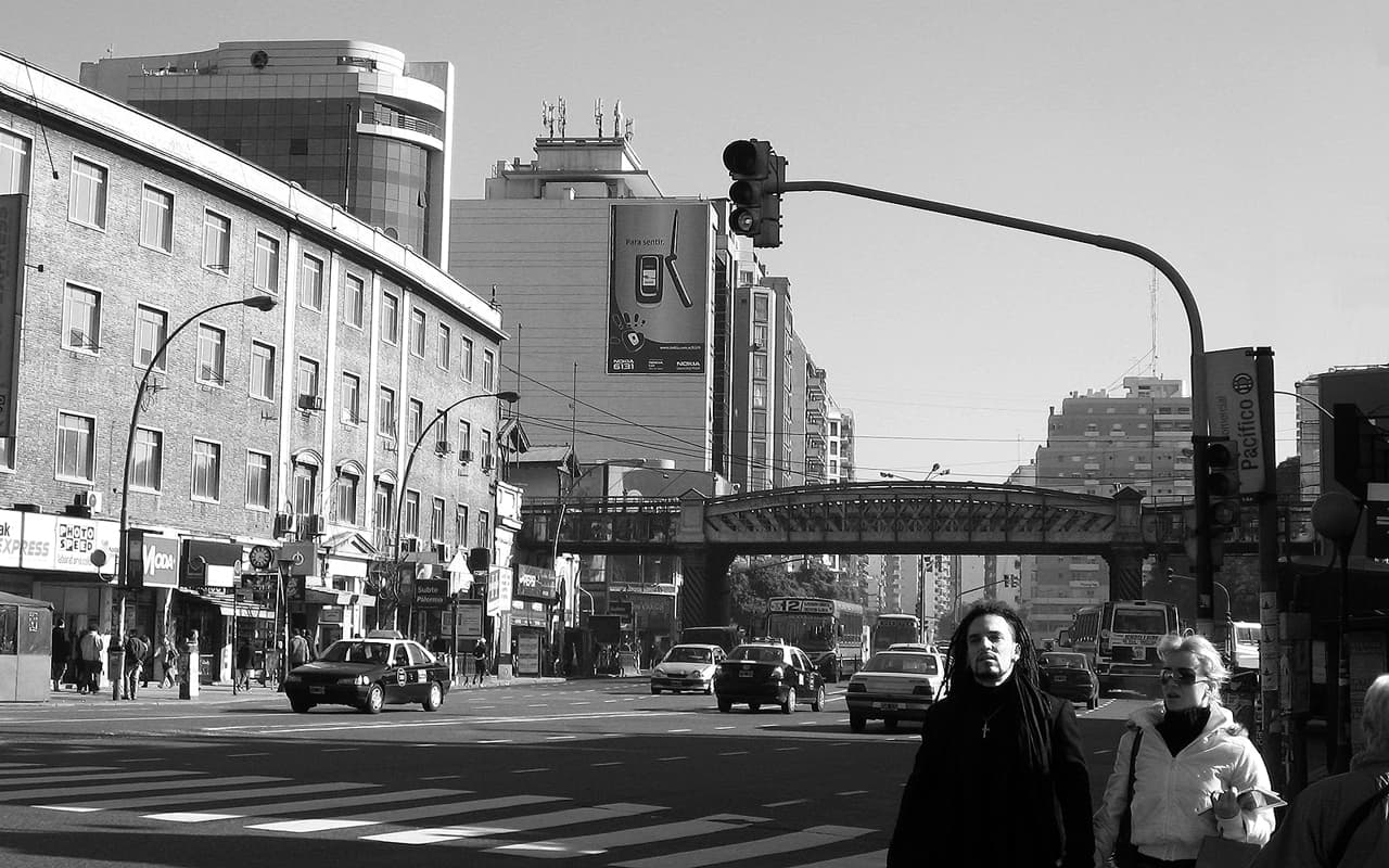 Urban scene on Santa Fe Avenue, featuring a railway bridge that crosses over the lanes. Located in the Palermo district of Buenos Aires, Argentina.