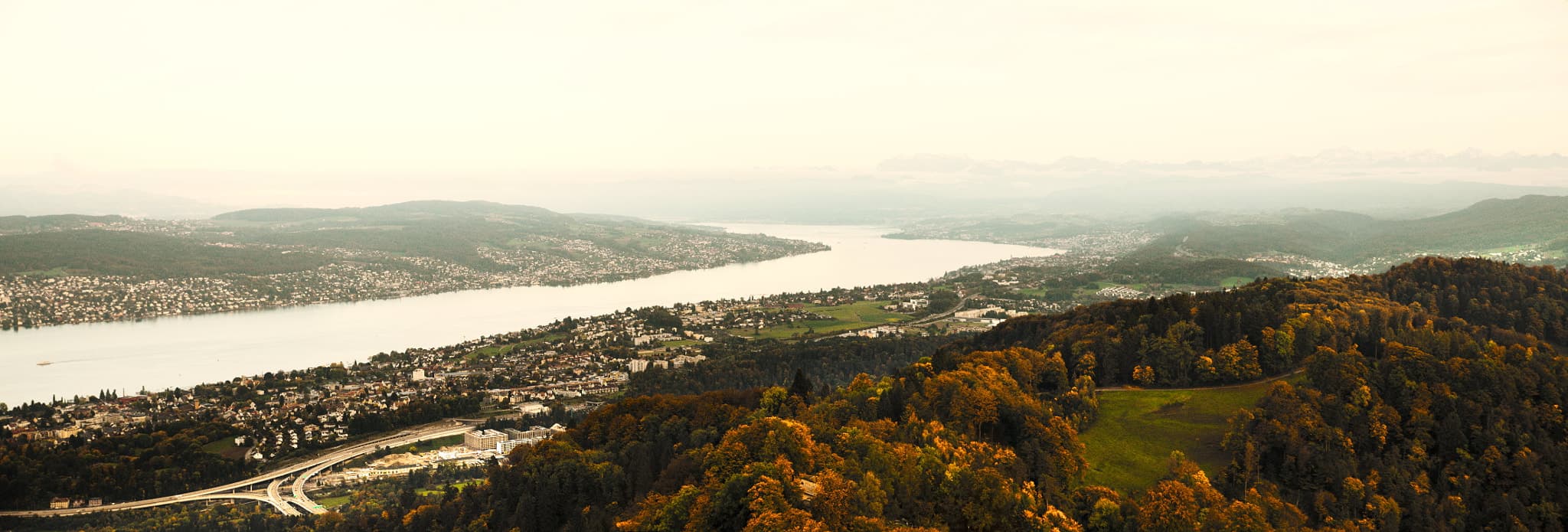 Lake Zurich, Switzerland, in autumn. A picturesque panorama showcasing the lake, surrounded by forests and a charming cityscape. This enchanting scene captures the beauty of nature during the golden hour.
