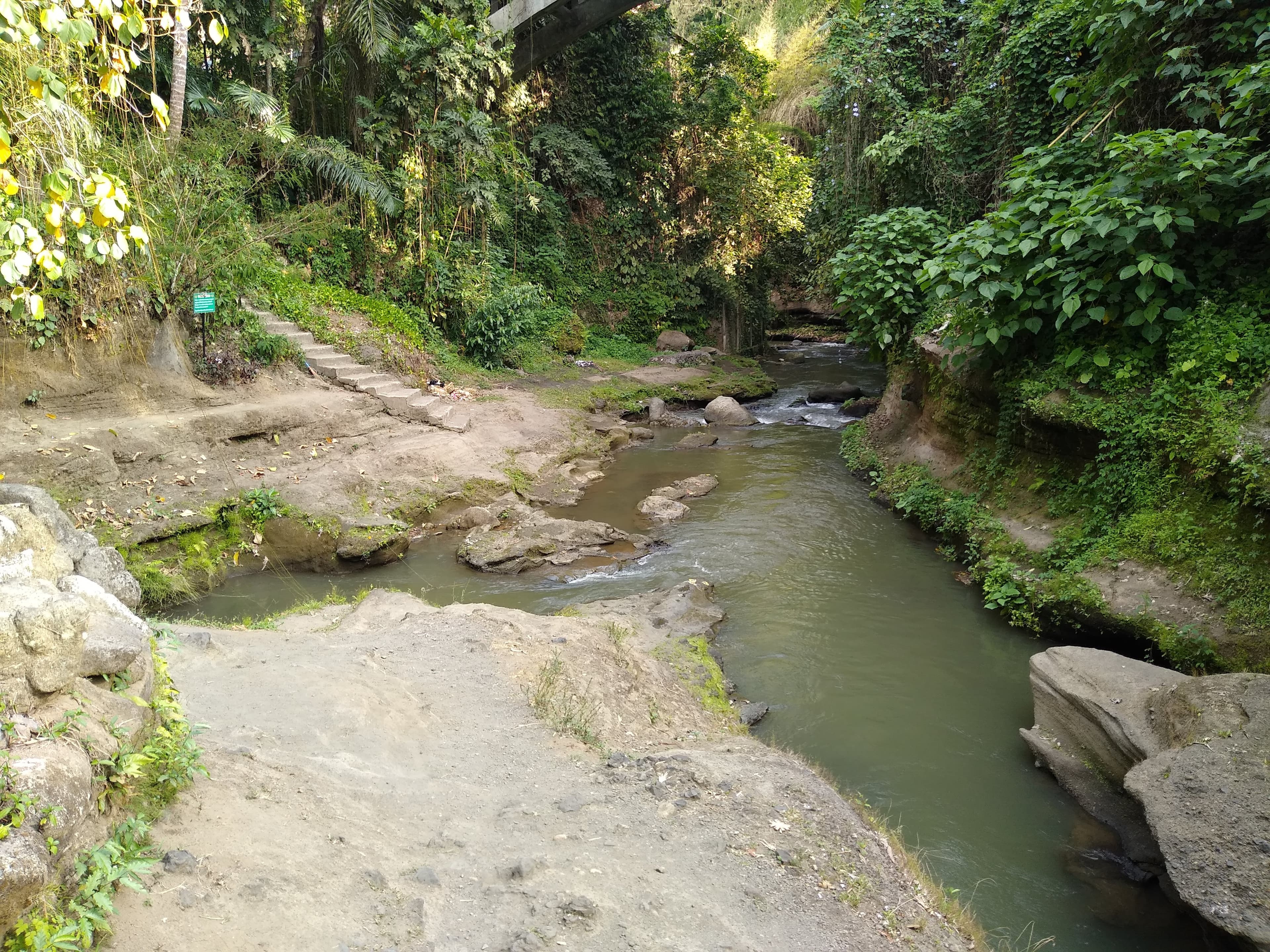 The meeting of the rivers at Campuhan, Bali, is described on the sign as follows: "Campuhan - the point where two rivers converge - is a very sacred energy center of Bali, activated by the holy man Ida Maha Rsi Markandeya."