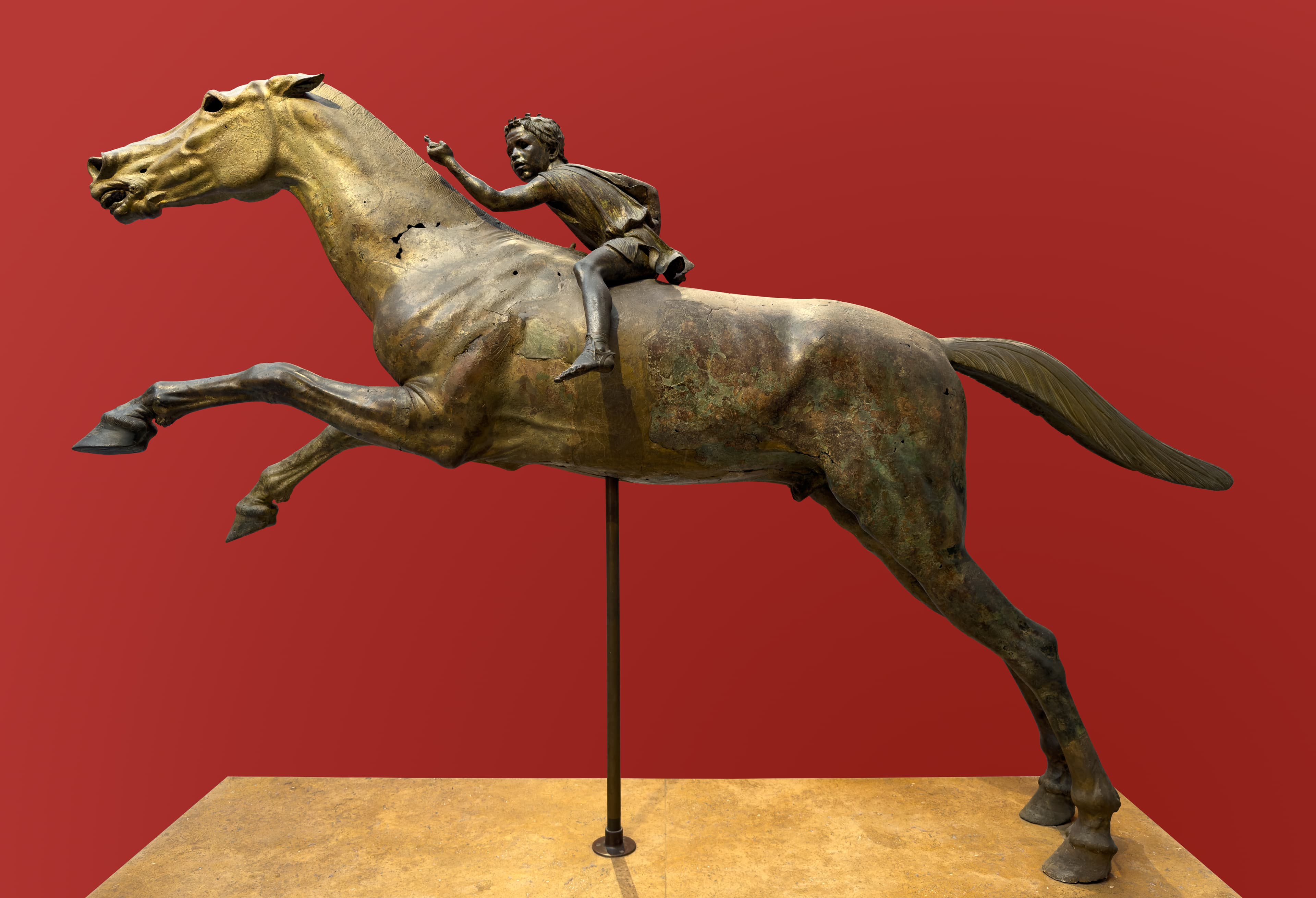 Jockey of Artemision on a red background.